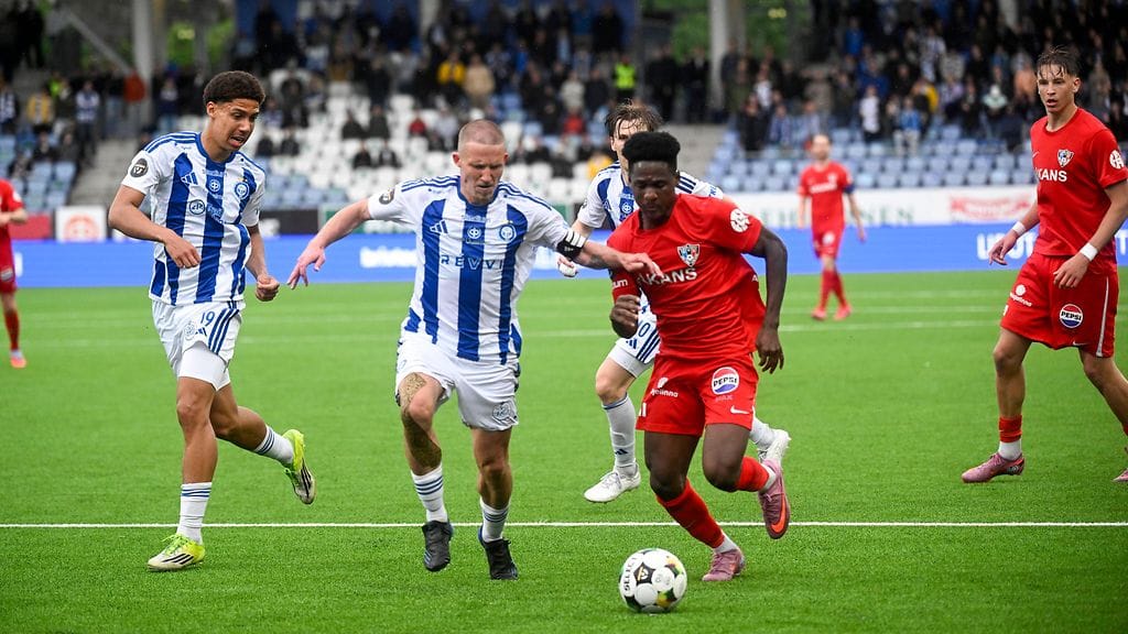 Alexander Ring ja Jean Botue tavoittelivat palloa keskiviikkona Töölössä. Taustalla tänään sääntöjen puitteissa kannattaneet HJK-fanit.