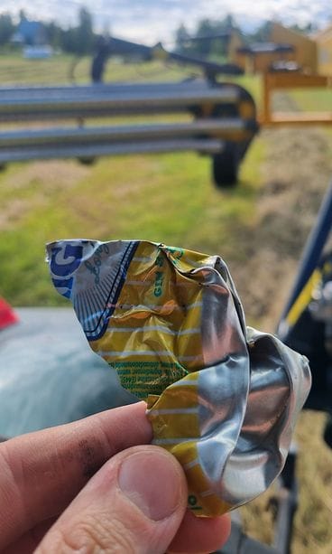 Eläin ei erota ruohossa tai rehun seassa olevia sirpaleita syödessään. Kuvituskuvassa puimakone ja lyttääntynyt metallitölkki.