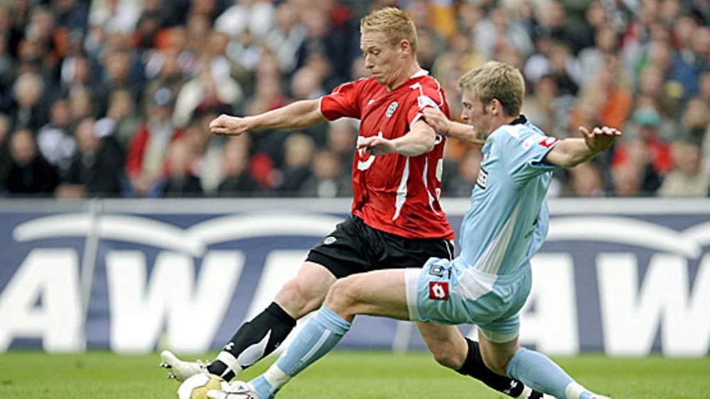 Mikael Forssell karkaa Mönchengladbachin Jan-Ingwer Callsen-Brackerilta. Kuva: Jochen Lübke/EPA.