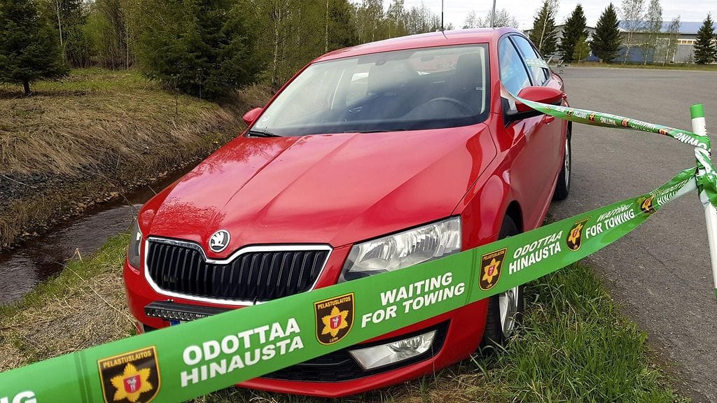 Lapin pelastuslaitoksen välittämä mallikuva liikenneonnettomuusajoneuvon tehostetusta merkinnästä eli odottaa hinausta -nauhalla merkitystä onnettomuusautosta. Handout.