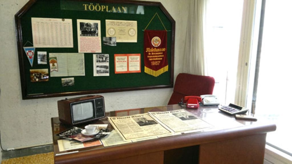 Johtajan pöydällä olevat sanomalehdet kertovat kahden eri valtiomiehen kuolemasta: teksti on sama, vain nimi ja kuva vaihtuvat.