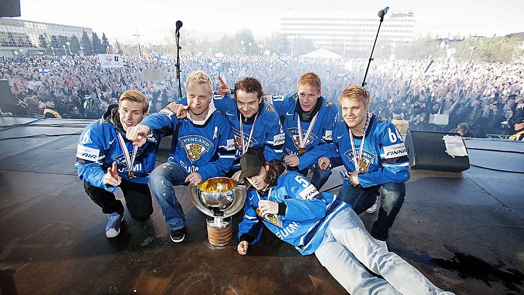 MM-Leijonien Topi Jaakola (vas), Lasse Kukkonen, Janne Pesonen, Mika Pyörälä ja Mikael Granlund sekä lattialla makaava Juhamatti Aaltonen kapusivat kansanjuhlan lavalle MM-pokaalin kanssa Oulussa.