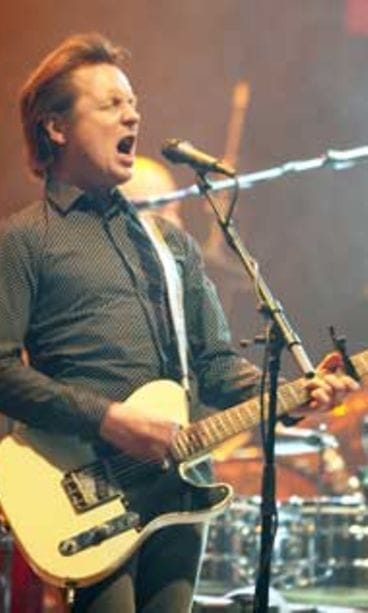 Mies ja kitara lavalla.